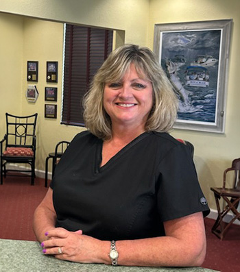 The image shows a woman standing behind a counter in an office setting.