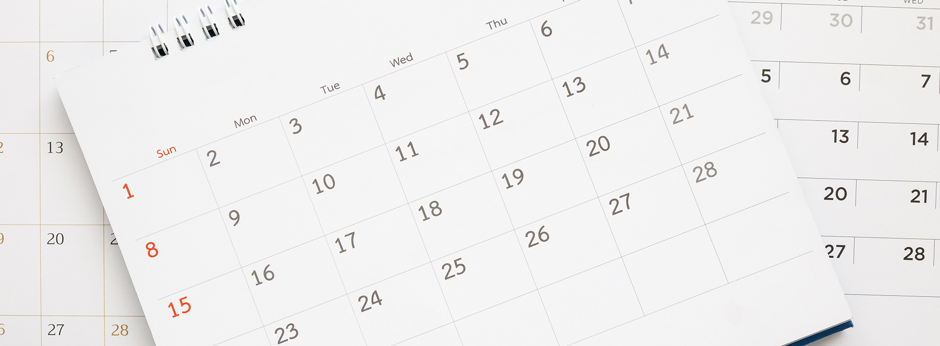 The image shows a physical calendar with the month of September visible, placed on a surface next to other calendars or papers.