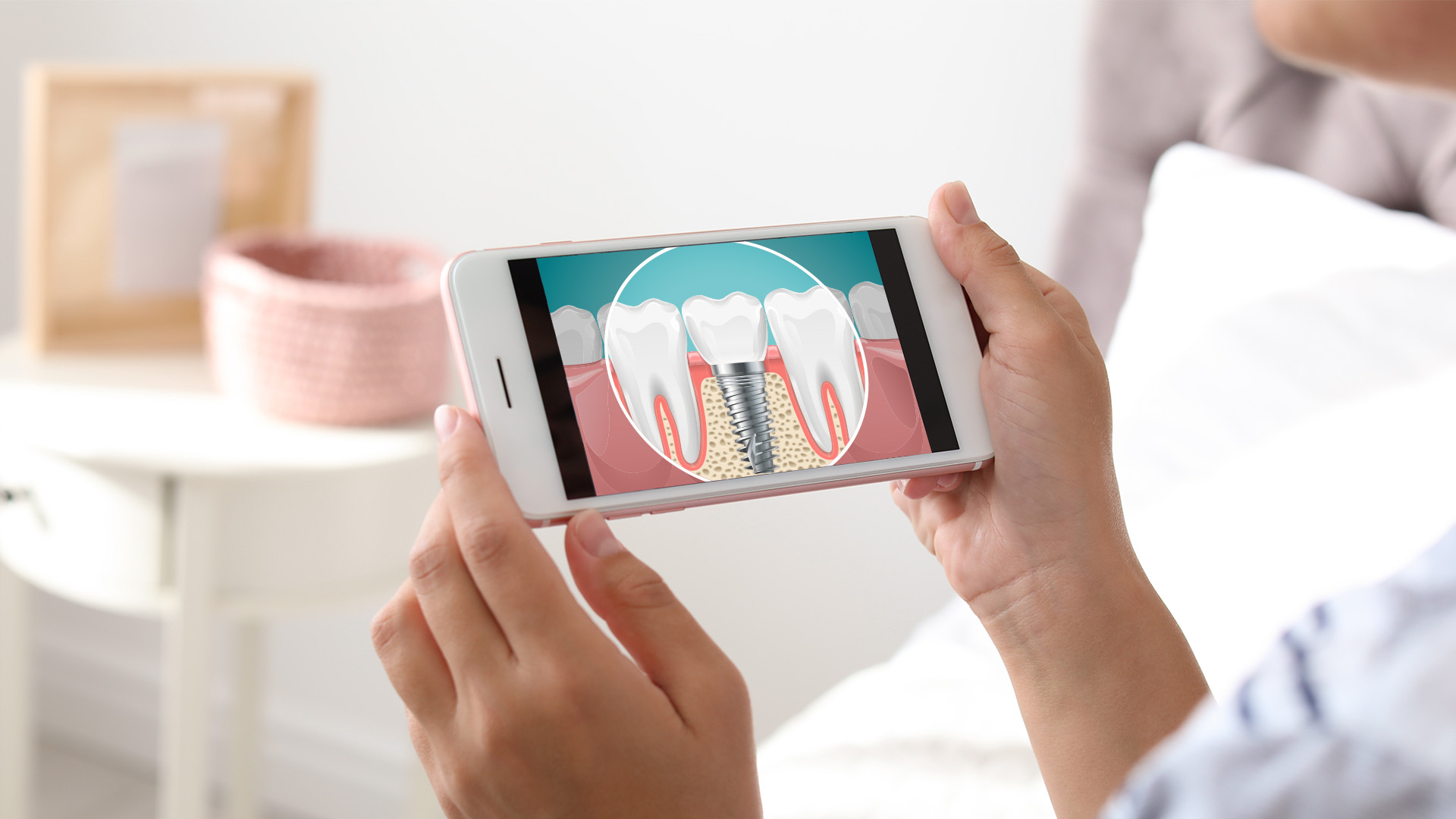 Person holding a smartphone displaying an image of a tooth with a magnified view of its surface and root.