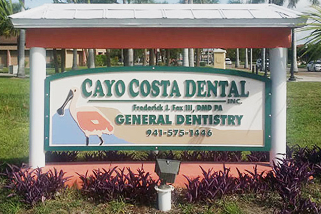 A sign for a dental practice named Cayo Costa Dental, with an address and contact information.