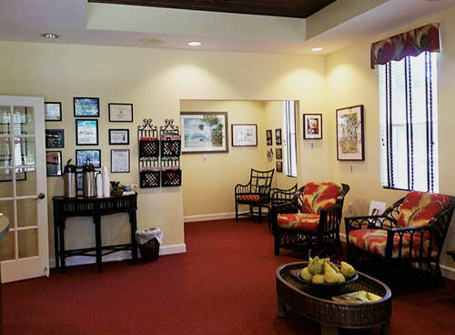 The image depicts an interior space, likely a waiting room or lobby, with a variety of furniture and decorations.