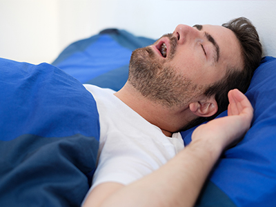 A man sleeping in bed with his head on a pillow.